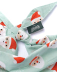 Bandana with Santa Claus pattern and 'The Paws' brand tag on a white background