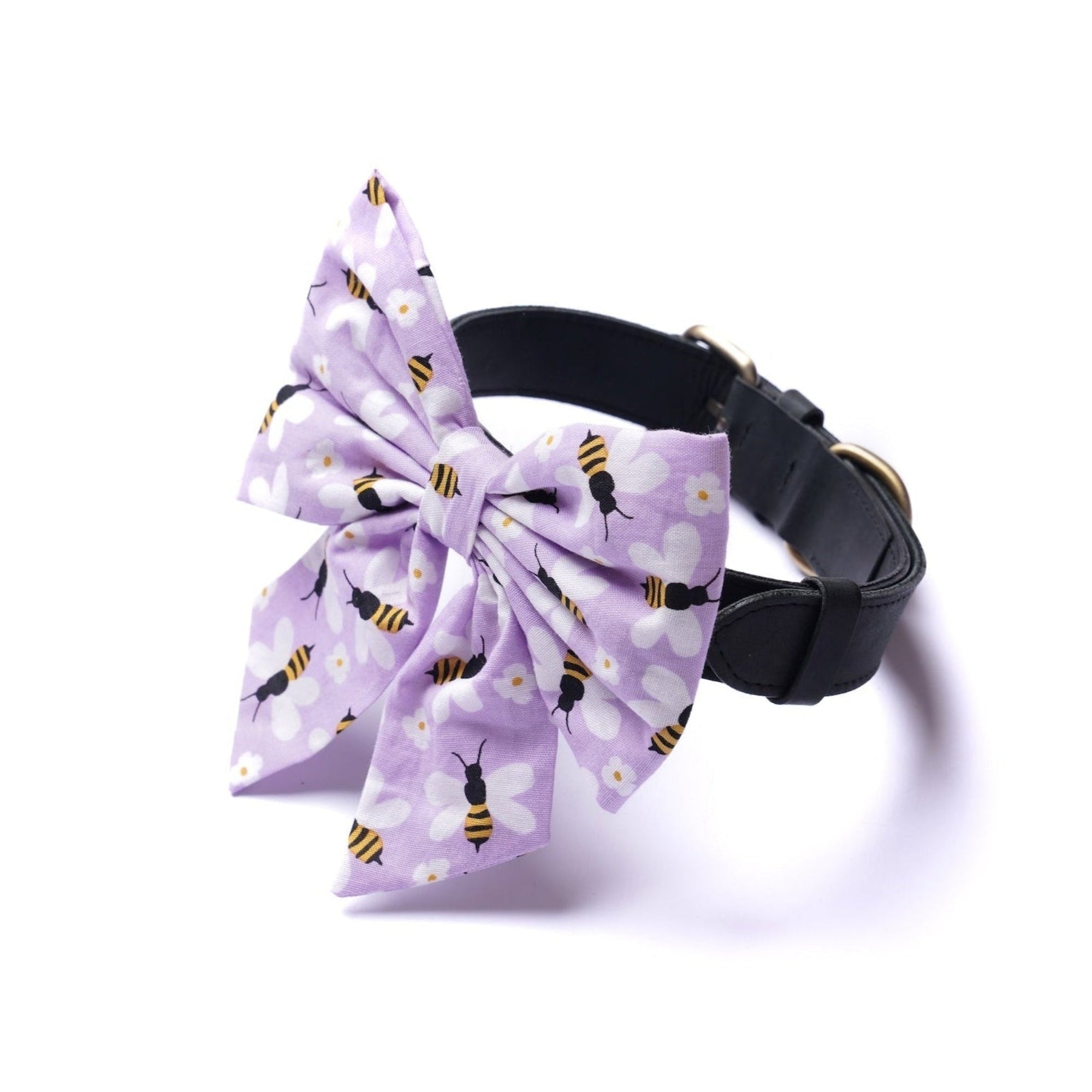 Dog collar with a large purple bow featuring bee patterns on a white background