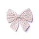 Large fabric bow with pink polka dots on a white background