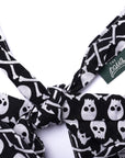 Black and white skull and bone patterned dog bandana with a visible brand tag on a white background